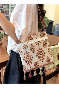 Vista detallada del bolso cruzado tejido de estilo étnico con borlas y patrones geométricos.