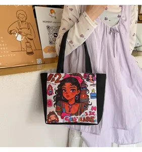 Vista detallada del bolso tote de lona negra con un bonito estampado de chica de dibujos animados.