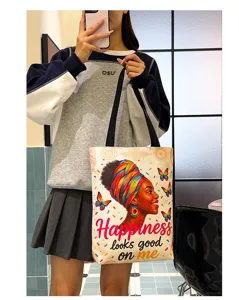 Large capacity canvas shoulder tote bag with artistic African woman graphic print detail.