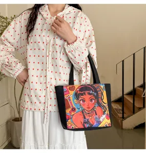 Detalle del bolso de lona con estampado de chica anime y asa negra resistente.