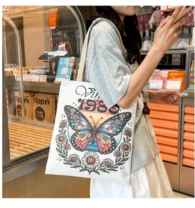 Vista detallada del bolso tote de lona informal con estampado de mariposa vintage y 1980.