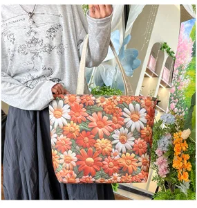 Vista detallada del bolso tote de lona bordado con flores, de gran capacidad.