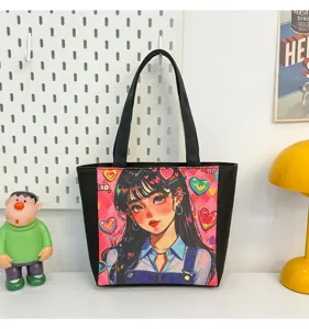 Detalle de bolso tote negro de lona con estampado de anime y asas muy resistentes.