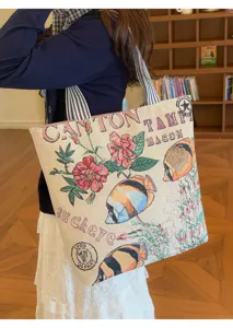 Vista detallada del bolso tote de lona estilo tapiz vintage con patron floral y peces.