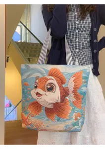 Vista detallada del gran bolso tote de lona tejida con bonito diseño de pez dorado.