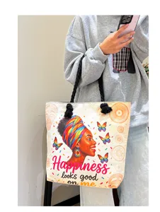 Detail van de canvas shopper met artistieke Afrikaanse vrouwenprint en stevige zwarte touwhandvatten.