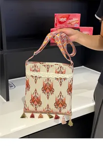 Bolso bandolera tejido de estilo étnico con un bonito ribete de encaje y borlas.