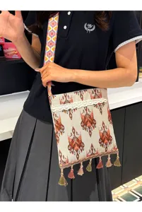 Bolso cruzado tejido de estilo étnico con correa colorida, flecos elegantes y gran detalle.