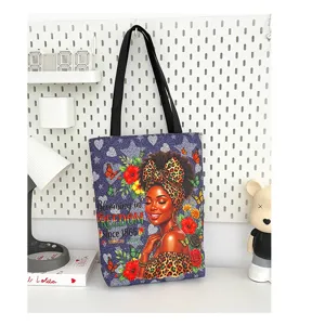Détail de sac cabas en toile avec impression d'art de femme noire et motif floral élégant.