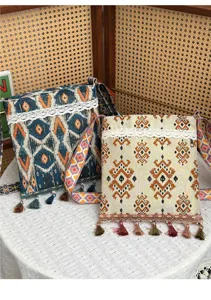 Bolso bandolera tejido de estilo étnico con patrones geométricos, encaje y borlas.