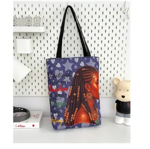 Vue détaillée du grand sac cabas en toile avec impression de femme noire et texte.