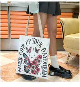 Bolso de hombro de lona informal grande con estampado de mariposas y texto inspirador.