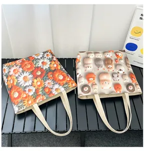 Vista detallada de dos bolsos tote de lona informales con estampados florales y de animales.