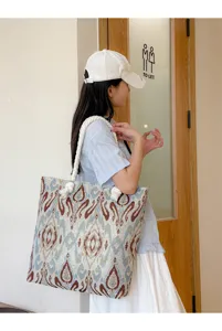 Large capacity ethnic totem embroidered canvas tote bag detailed side view on model
