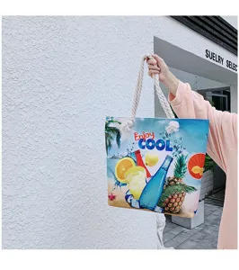 Dettaglio della borsa shopper da spiaggia in tela con stampa di frutta tropicale e manici.