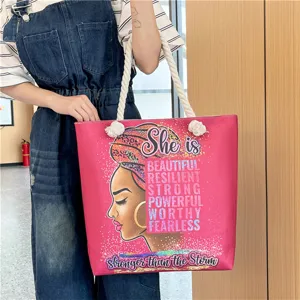 Detailed view of the pink canvas tote bag featuring an artistic portrait and motivational text.