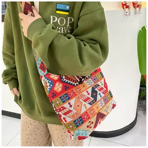 Close-up of ethnic embroidered crossbody saddle bag, showing colorful woven geometric patterns.