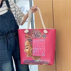 Close-up detail of the African woman print canvas beach bag with thick rope handles.