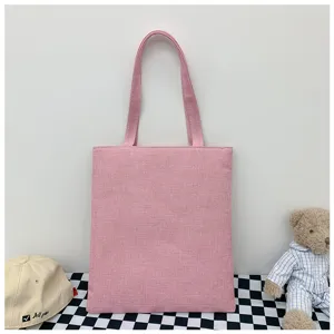 Vista dettagliata della borsa tote in tela di lino rosa con doppi manici in un'accogliente scena.