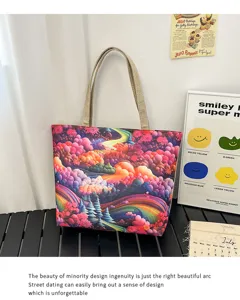 Vista detallada del bolso tote de lona con estampado paisajístico artístico y asas resistentes.