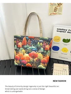 Primer plano detallado del bolso tote de lona con estampado de bosque artístico y colores otoñales.