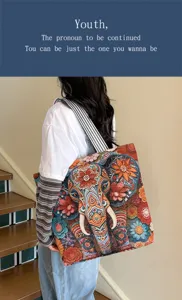 Détail du sac cabas tissé à motif d'éléphant ethnique avec des fleurs colorées.
