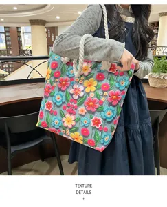 Vista dettagliata della borsa tote in tela con fiori colorati, ricami in rilievo e manici in corda.
