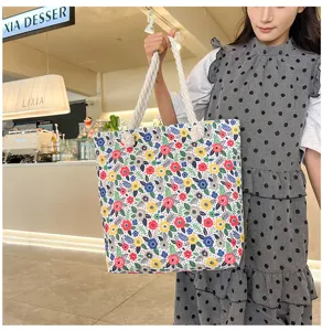 Detailed view of the floral canvas tote bag featuring thick rope handles and print.