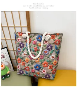 Dettaglio della borsa shopper in tela ricamata a fiori con manici spessi in corda colorata.