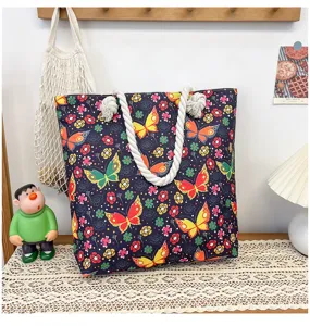 Detailed view of canvas beach tote bag featuring vibrant butterfly patterns and thick rope handles.