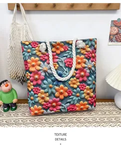 Canvas beach tote bag detail view featuring colorful floral pattern and thick rope handles.