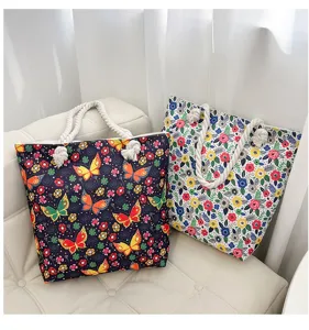 Casual canvas tote bag with butterfly floral print and thick rope handles for beach shopping.