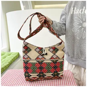 Detailed view of ethnic style woven shoulder bag with geometric patterns and wooden toggle.
