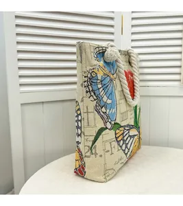 Grote canvas tote tas met elegante vlinderborduursel en vintage krantenprint patroon.