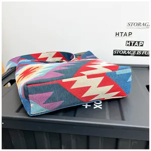Close-up detail shot of boho ethnic woven shoulder saddle bag with colorful geometric pattern.