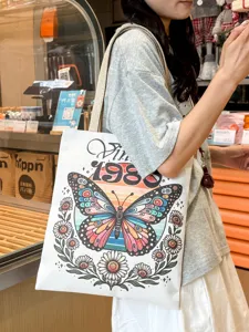 Vista dettagliata della grande borsa di tela con stampa di farfalle e margherite vintage.