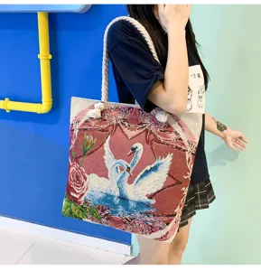 Vue détaillée du sac cabas en toile jacquard avec un élégant motif de cygne et de rose.