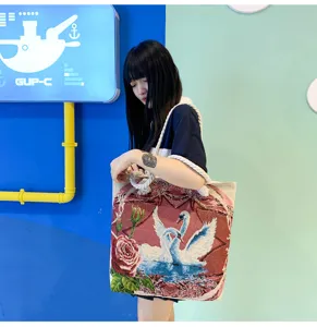 Vue détaillée du sac cabas en toile de tapisserie cygne vintage porté par un modèle.
