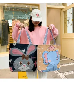 Primo piano dettagliato di simpatiche borse tote in maglia con motivi di coniglio ed elefante.