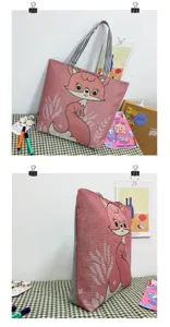 Vista dettagliata della borsa tote in tela con volpe cartoon, tessuto intrecciato e manici a righe.