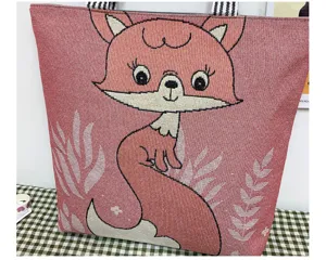 Primo piano della borsa di tela con simpatico muso di volpe cartoon e manici a righe.