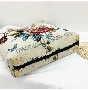 Détail du sac cabas en toile tissée à motif floral vintage avec roses et papillons.