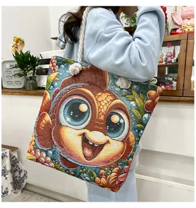 Detailaufnahme einer gewebten Schultertasche mit niedlichem Fischmotiv und Kordel.
