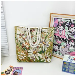 Bolso de lona con bordado floral y detalle de asa de cuerda mostrado en una escena.