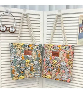 Detaillierte Ansicht der Segeltuchtasche mit niedlichem Katzenmuster und Schulterriemen.