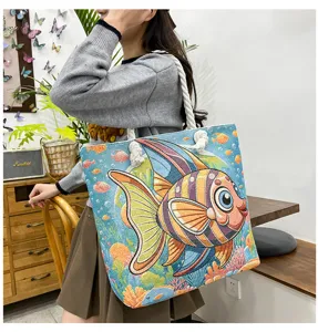 Lässige Canvas-Tote-Bag mit buntem bestickten Fischmuster und stabilen Tragegriffen.