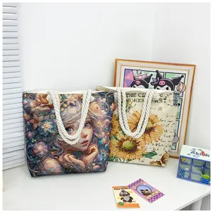 Vista detallada de bolso tote grande de lona con estampado floral artístico y asas de cuerda.