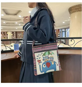 Vue détaillée du sac bandoulière en toile brodée ethnique mignon avec des motifs d'éléphant.