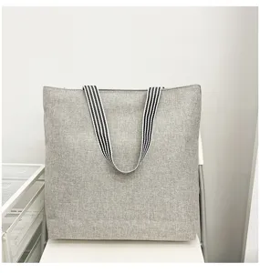 Grijs canvas shopper tas detail toont duurzame stofstructuur en gestreepte hengsels.