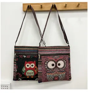 Détail du sac bandoulière en toile brodé de hibou avec motif ethnique coloré et poche avant zippée.
